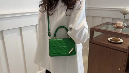 Bolsa de ombro moderna em couro sintético com alça ajustável, fecho magnético e detalhes dourados.