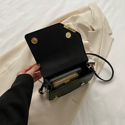 Bolsa de ombro moderna em couro sintético com alça ajustável, fecho magnético e detalhes dourados.